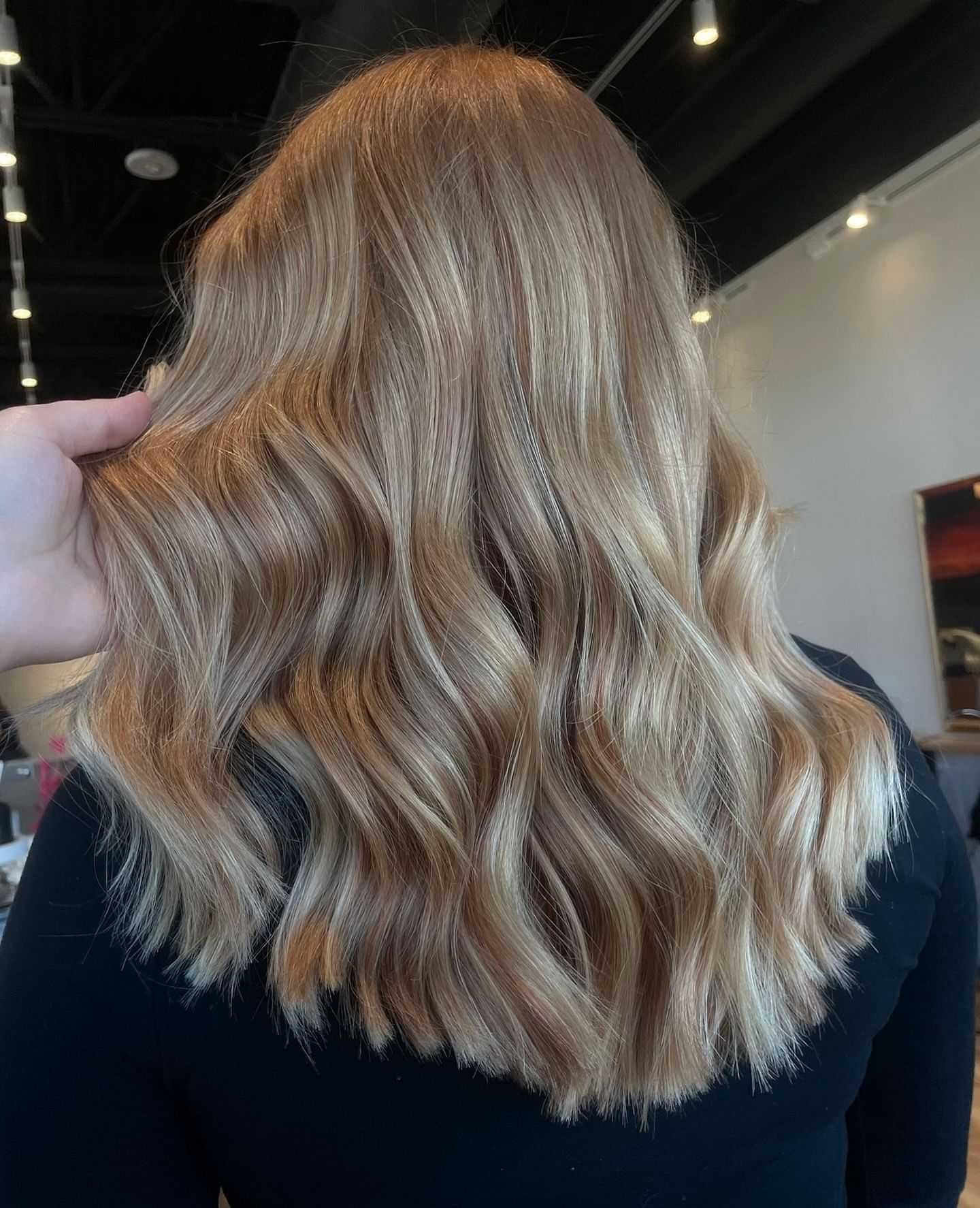 Back view of person with wavy caramel blonde hair.